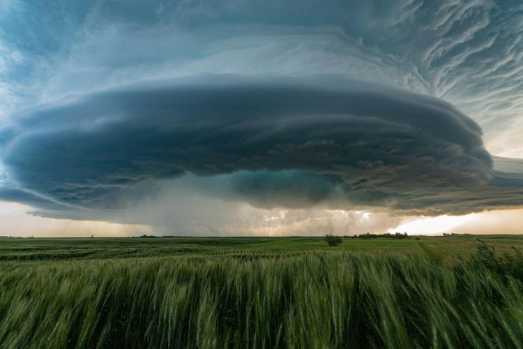 A large storm forming over a farm field.