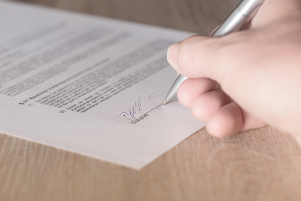 Someone signing a farmland lease agreement.