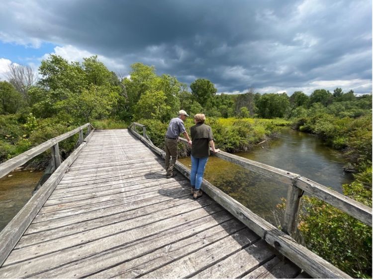 Lydia Kiewra, PhD student in STPAM, engaging in conversation with one of the Michigan DNR Wildlife Division’s Regional Supervisors. They overlook a potential study site to examine visitor use, the Sturgeon River (one of the three Blue Ribbon Trout Streams in the Pigeon River Country State Forest).