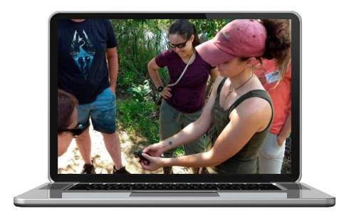 person holding turtle showing other people in a Michigan pond