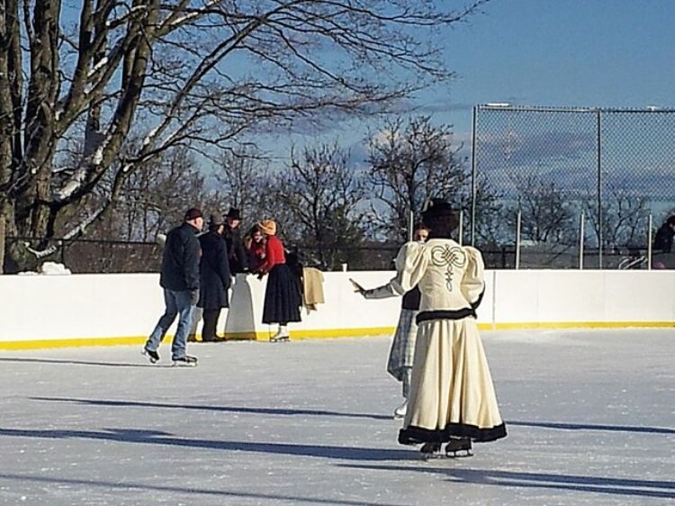 Photo of people ice skating at an outdoor rink.
