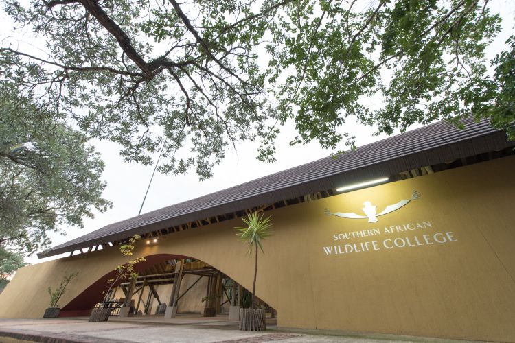 An image of the front entrance of a building with a sign denoting 