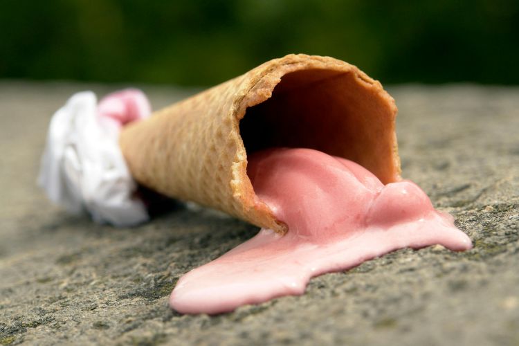 A spilled ice cream cone on the concrete.