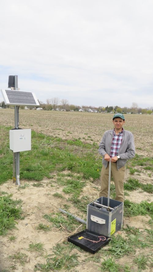 Ehsan Ghane stands with a controlled drainage structure in Elkton, MI. Photo credit: Anonymous
