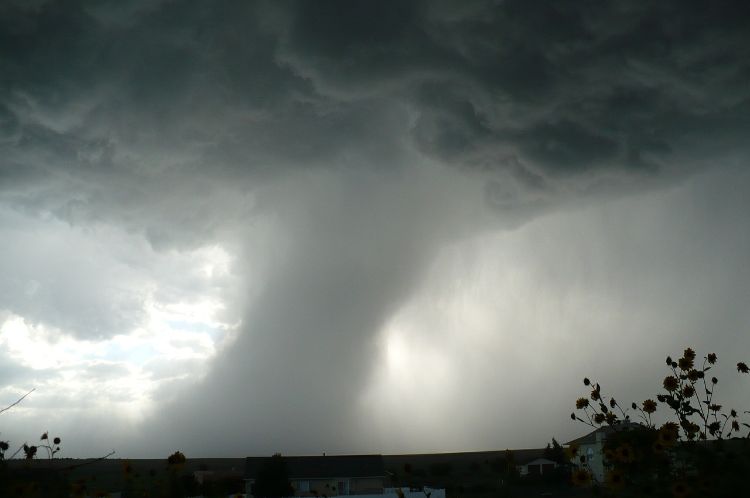 A funnel cloud in a grey sky.