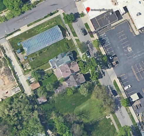 Aerial Photo of Earthworks Urban Farm in Detroit, showing streets, a high tunnel, Capuchin Kitchen, a parking lot and parts of a city neighborhood.