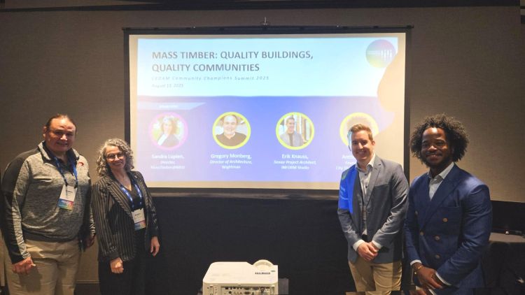 Panelists posing for a picture in front of a projector screen.