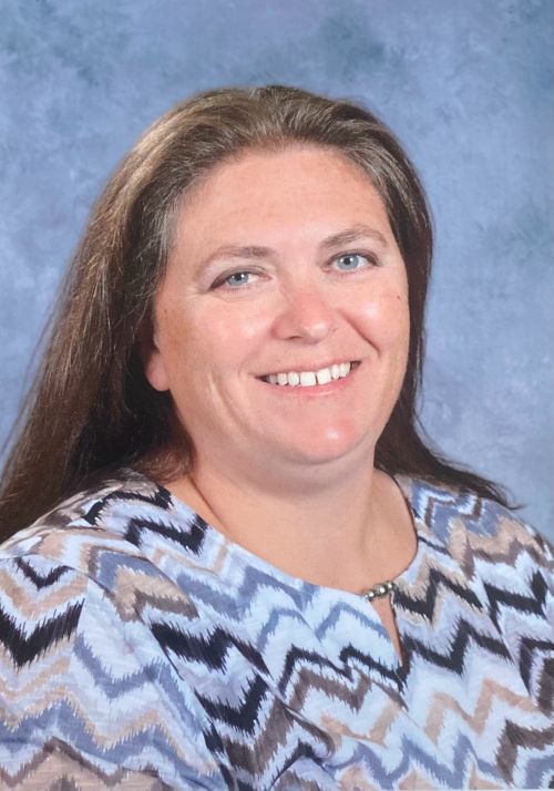 Dark haired Caucasian woman with a printed shirt.
