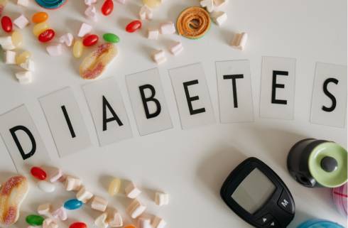 The word Diabetes with a glucose monitor at the bottom and pieces of candy