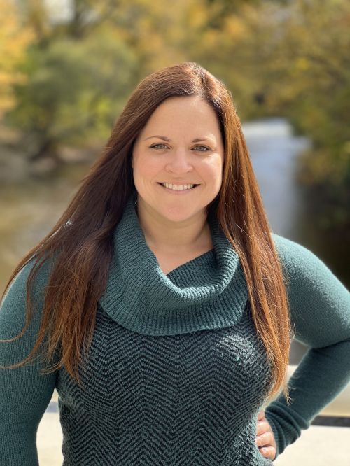 Dark haired Caucasian woman in green sweater.