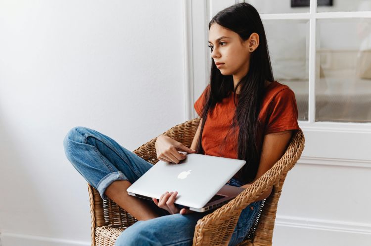 Picture of a girl sitting in a chair staring off into space.