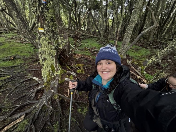 Kenna Kline, undergraduate forestry student, hiking surrounded by trees.