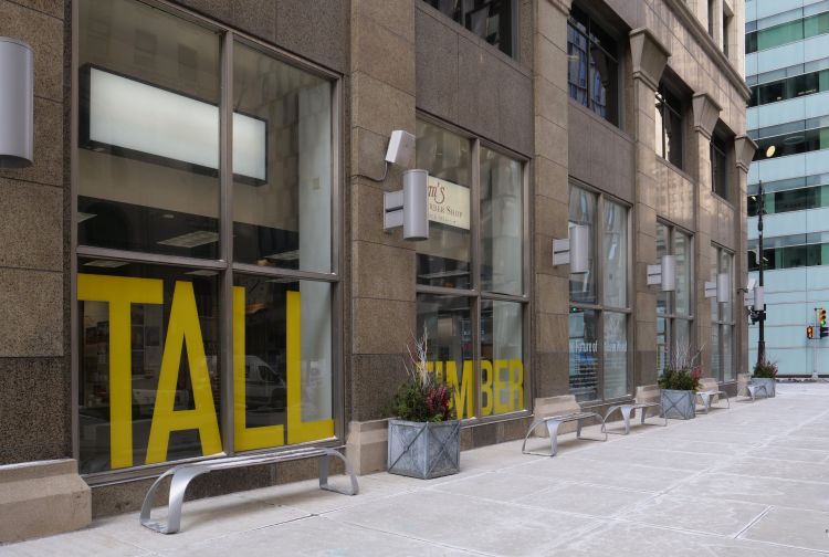 Exterior shot of a building with tall glass windows displaying 