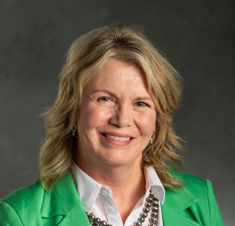 A headshot of Karen Waite with a dark grey backdrop
