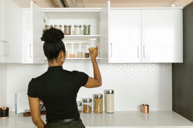 A woman rotating food in her pantry.