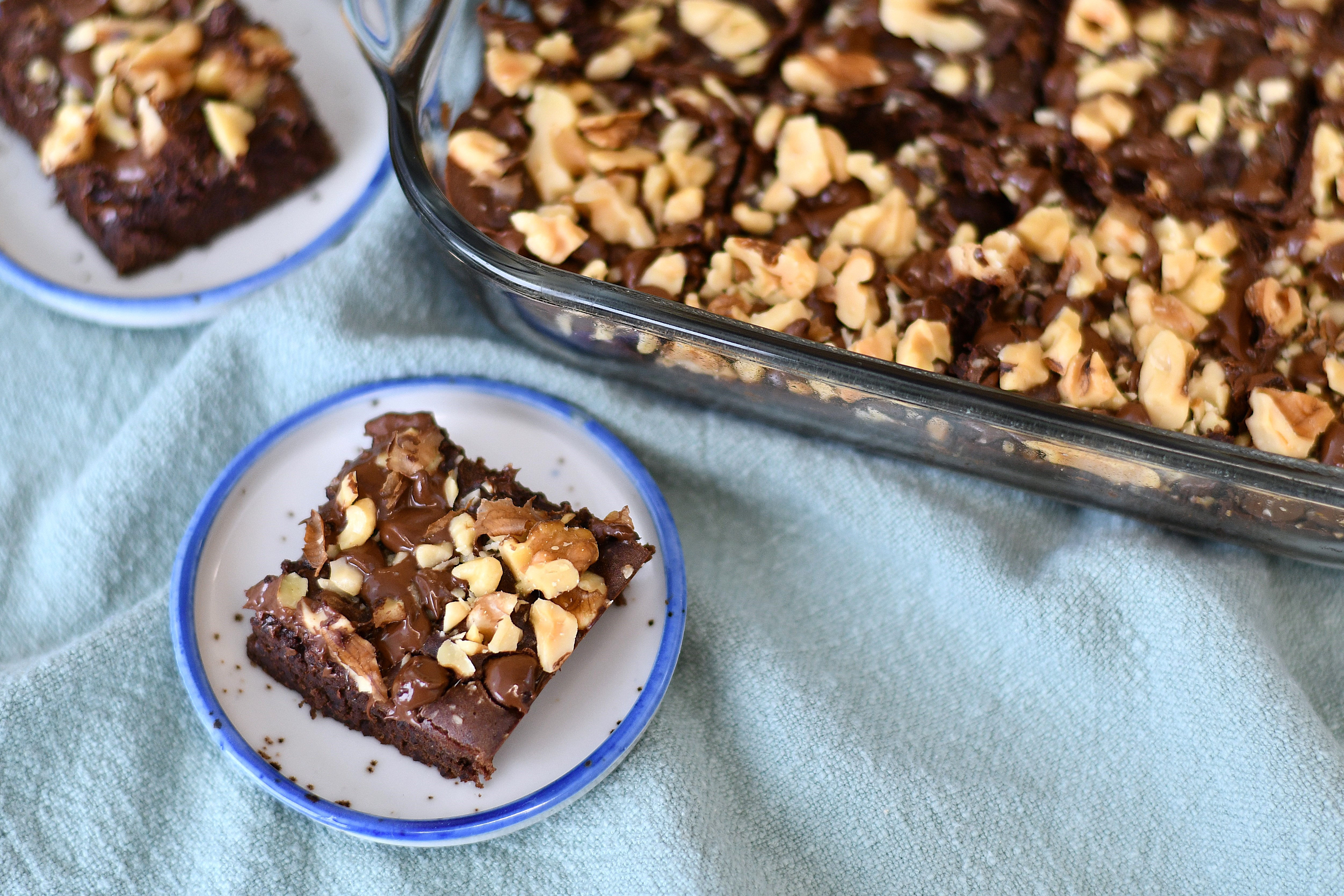 A photo of a brownie with nuts on a plate