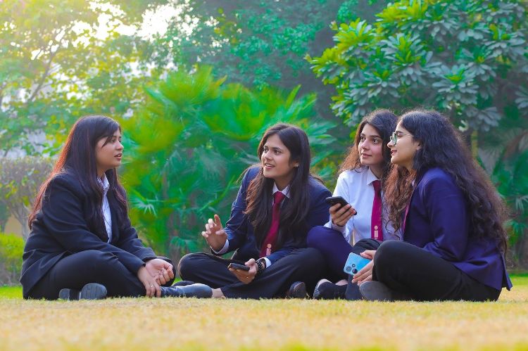 Young women sitting cross legged on the floor.