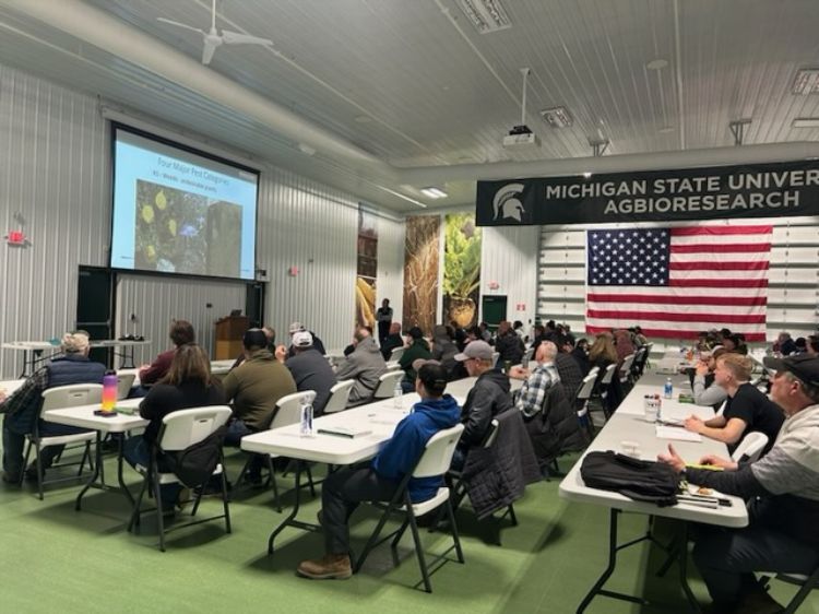 People sitting in a classroom looking a presentation.