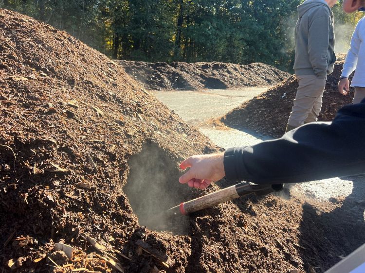 shovel stuck in a steaming pile of brown compost