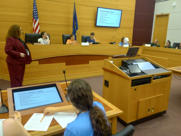 Youth sitting in a mock court room.