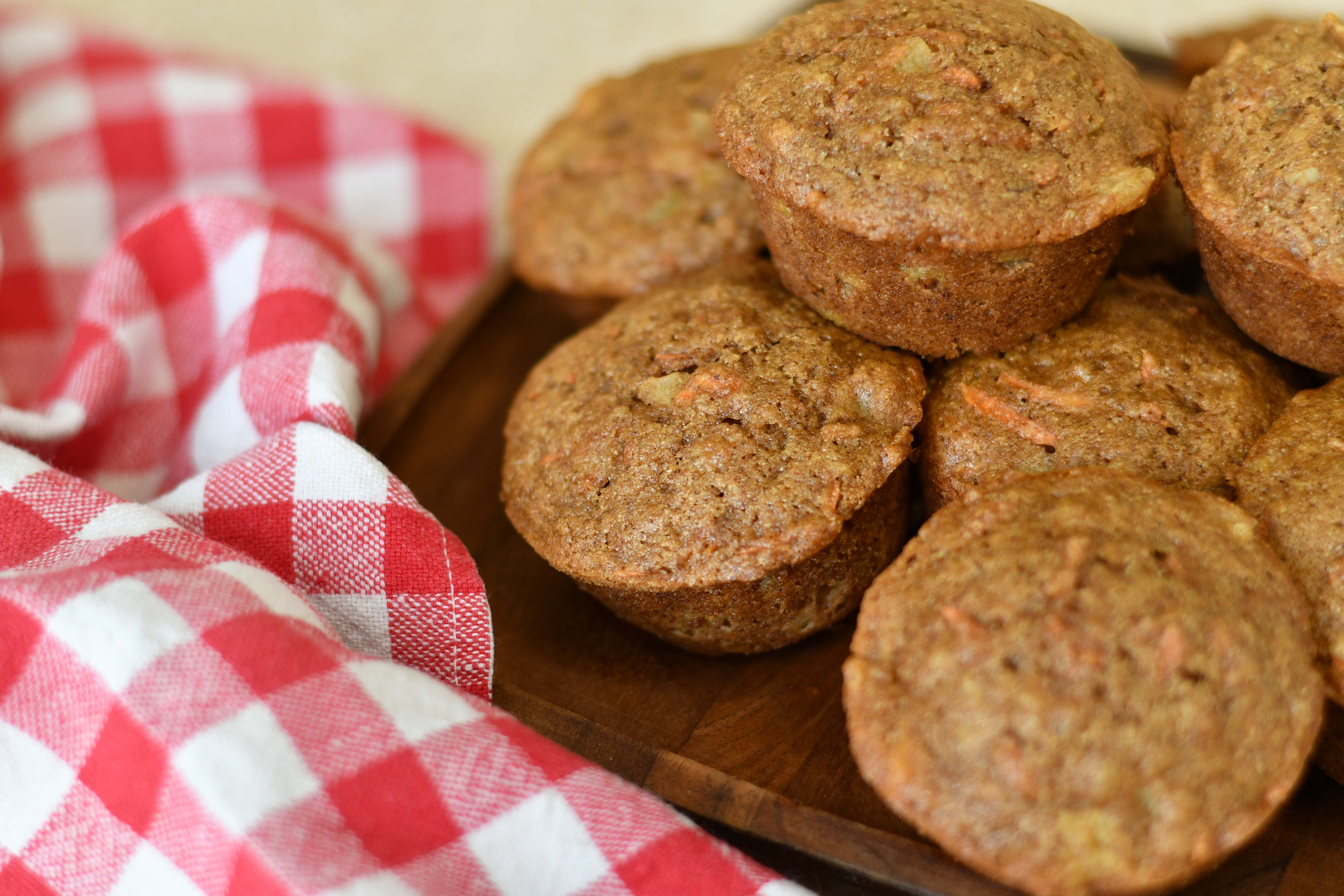 A photo of a group of muffins on a wooden plate