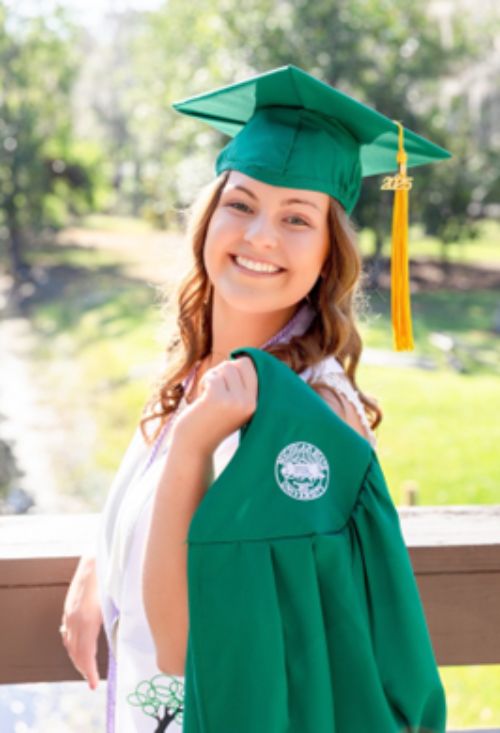 photo of a woman in a green graduation cap and gown