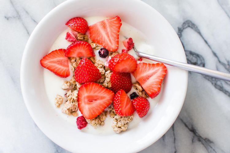 Cereal with fresh strawberries in a bowl.