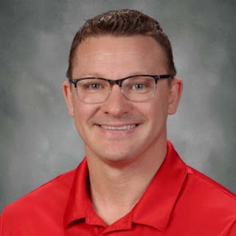 A man with dark hair, glasses and a red shirt.
