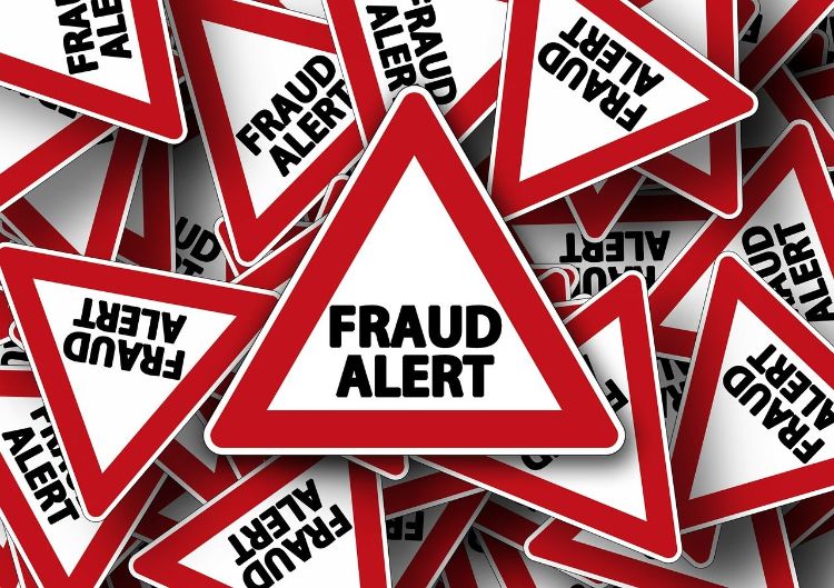 A bunch of triangle warning signs that have a red outline and black words that say Fraud Alert.