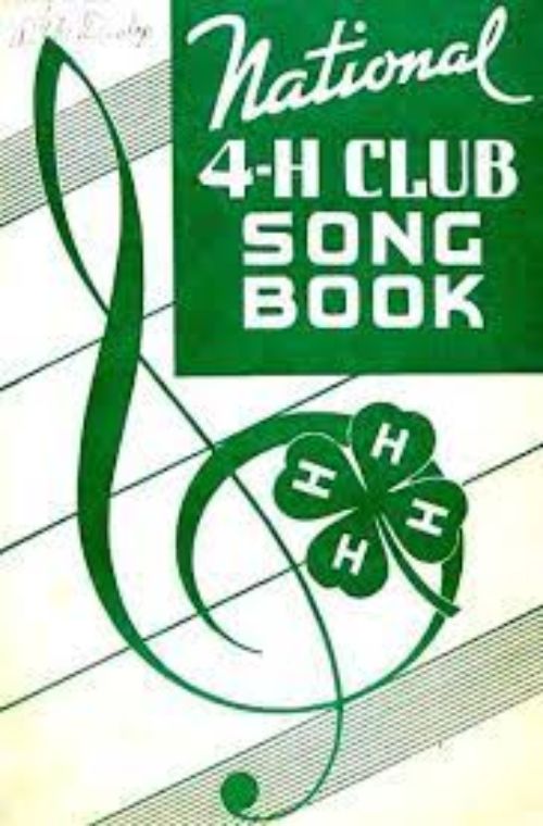 An old song book cover that has a green treble clef and green clover and the words 