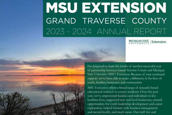 cropped image of the front of grand traverse county annual report. says msu extension, grand traverse county, 2023-2024 annual report with the start of an introduction by jennifer berkey, which is cut off by the cropping. this text is set on a green, semi transparent box that overlays an image of grand traverse county bay taken at sunrise.
