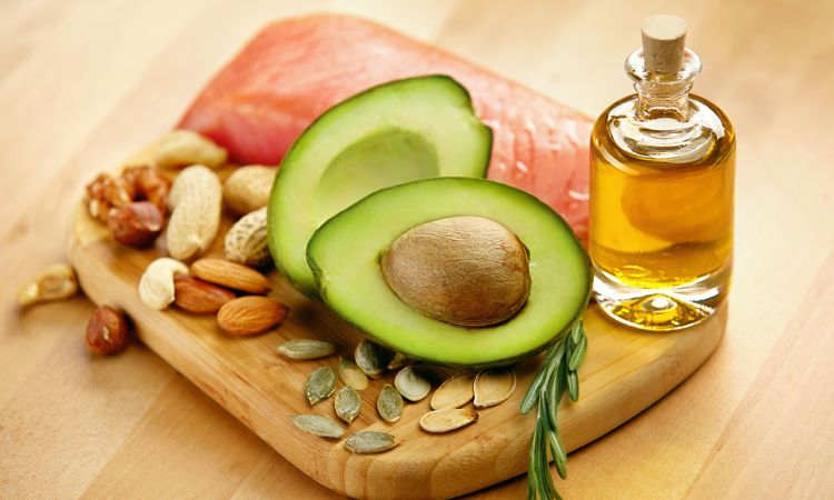 Photo of avocado, nuts, seeds, salmon, and oil.