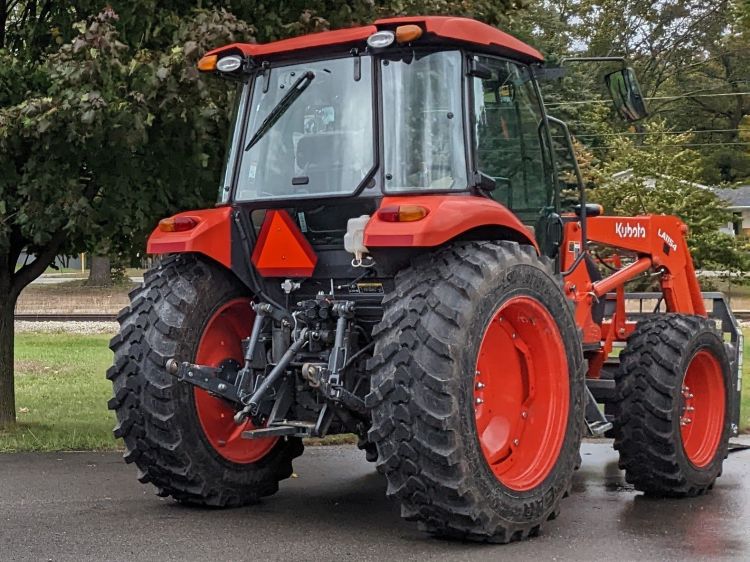 red tractor with slow moving vehicle attached