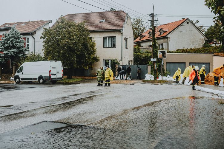A flooded house with workers outside.