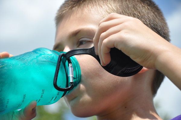 A photo of a child drinking from a water bottle.