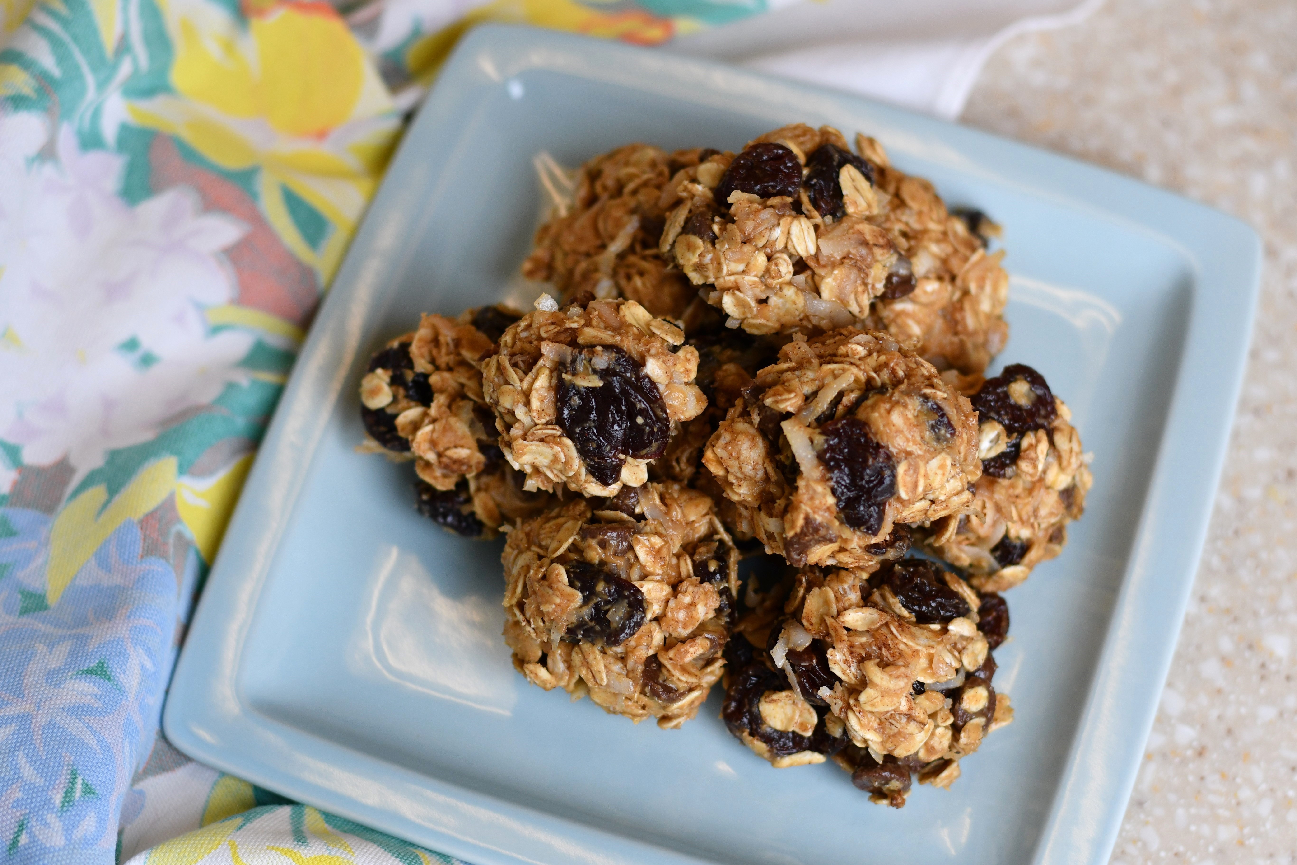 A photo of a plate of an oatmeal raisin mixture in a ball shape