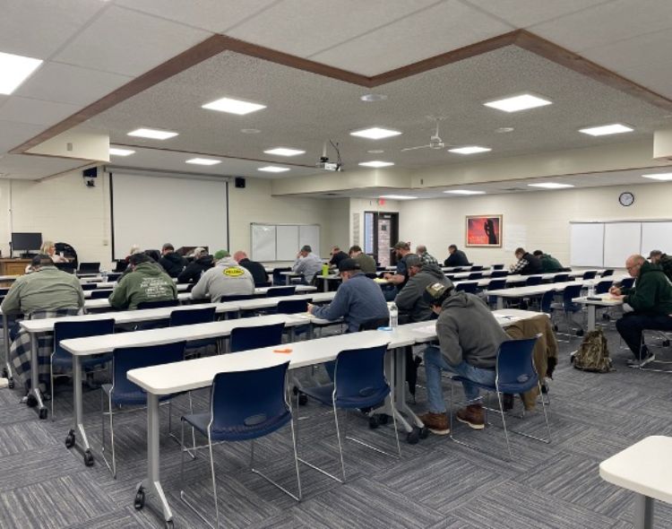 People sitting in a classroom taking a written test.