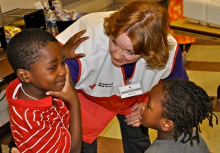 Red Cross volunteer comforts a child following a tornado, embodying the “helper” spirit Fred Rogers encouraged. Source: American Red Cross public domain-image North Dakota/South Dakota region.