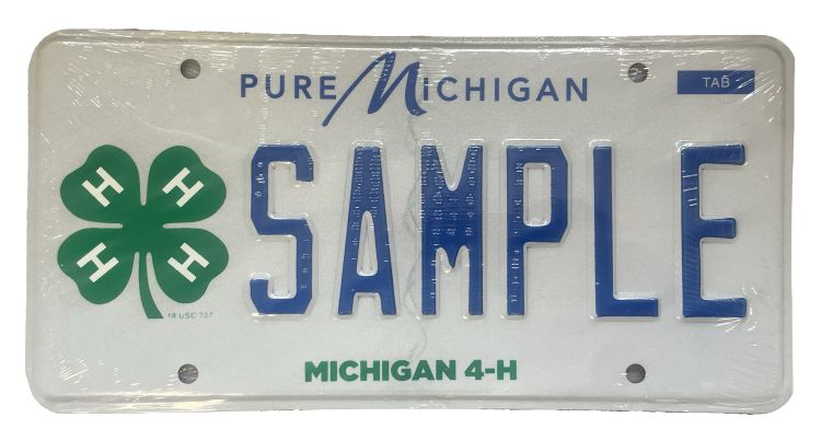 White license plate with green 4-H clover on left and Michigan 4-H along the bottom. In blue across the top is Pure Michigan and across the middle SAMPLE.