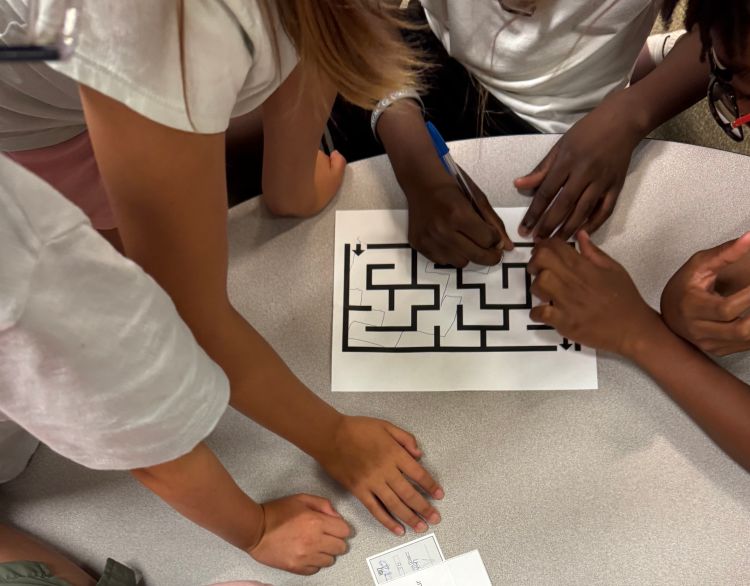 Hands on top of a paper maze.