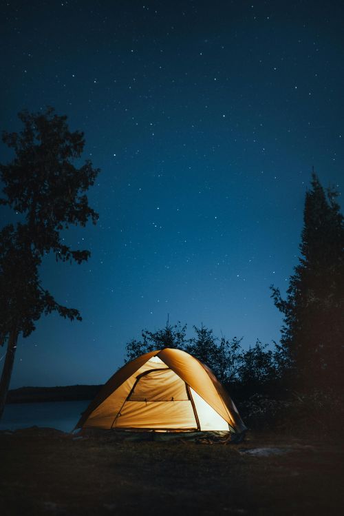 A tent set up under the nighttime sky.