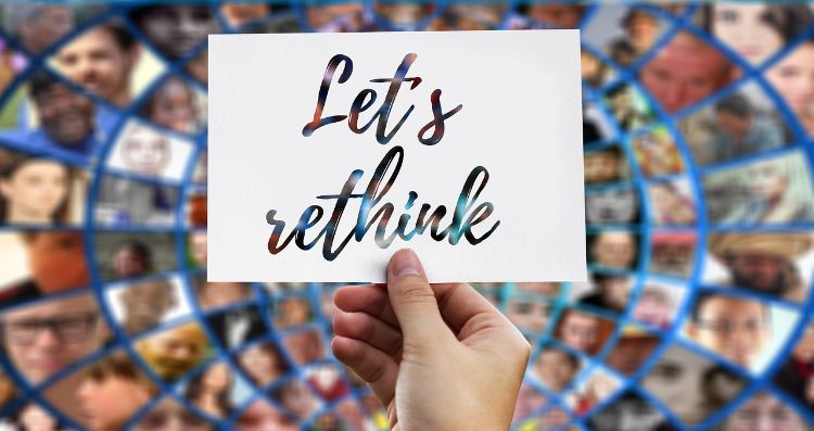 A person's hand  holding a sign that says: 