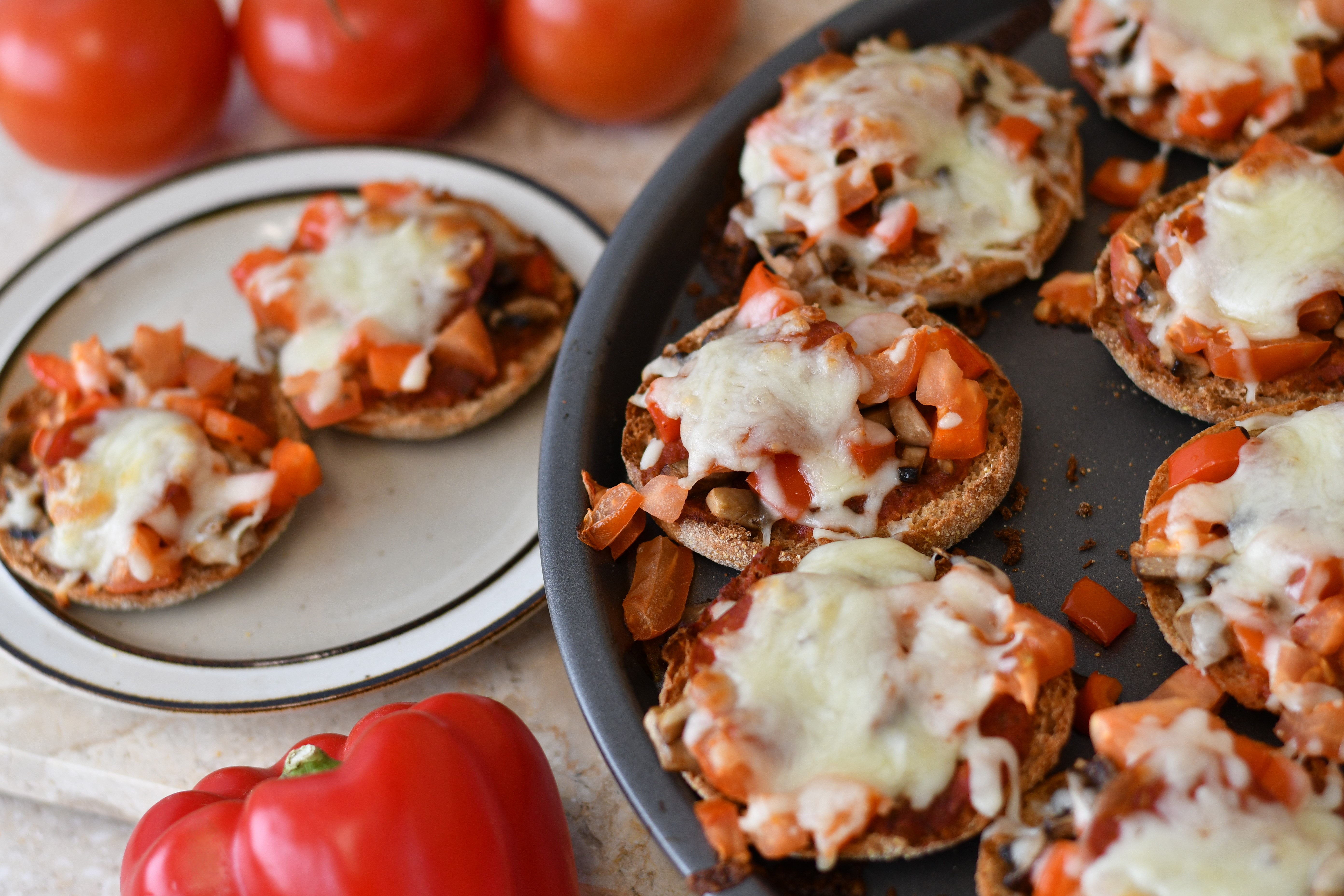 A photo of a pan of pizzas with tomatoes and cheese