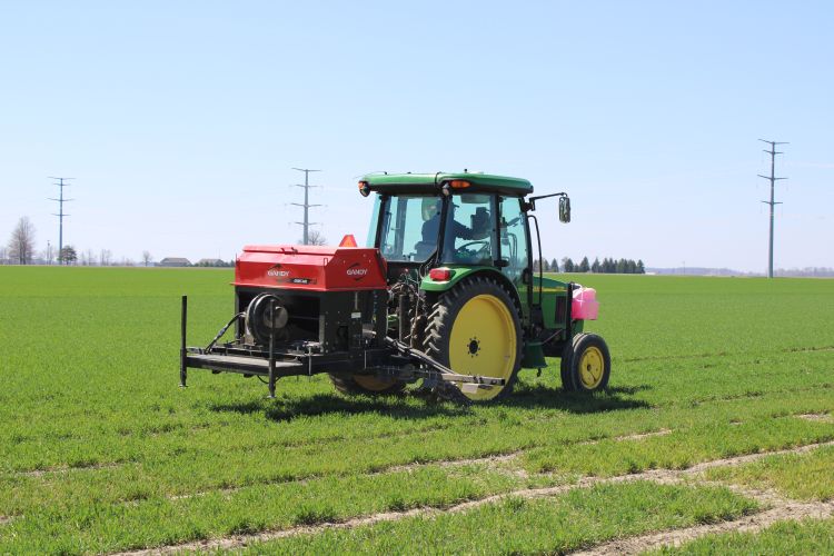 green implement spraying in a green field