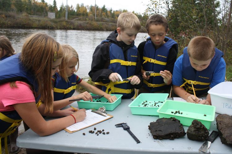 Alpena youth monitor invasive zebra mussel populations in Thunder Bay River. Photo: Michigan Sea Grant