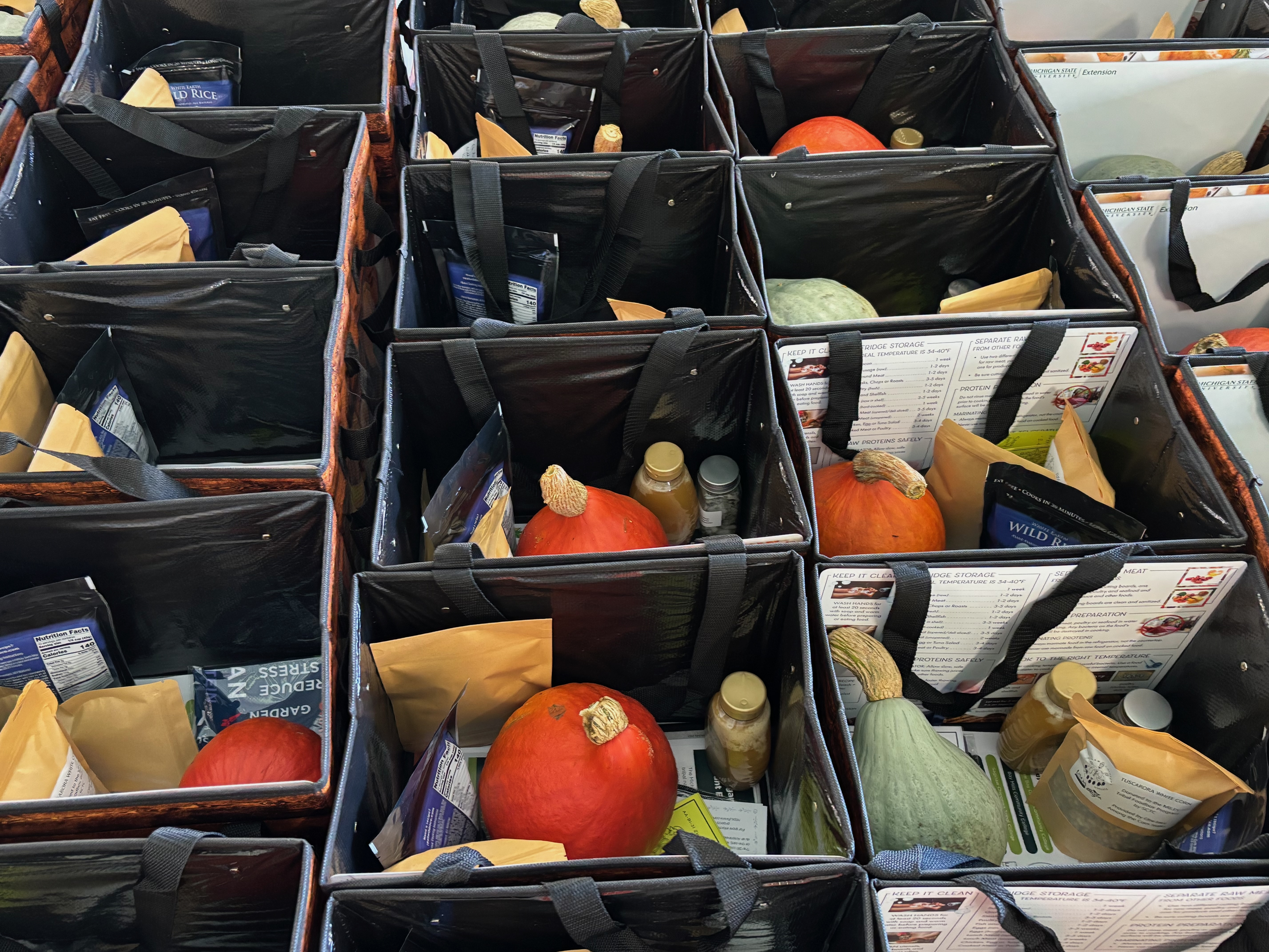 Tote bags filled with squash, wild rice, and various packaged foods.