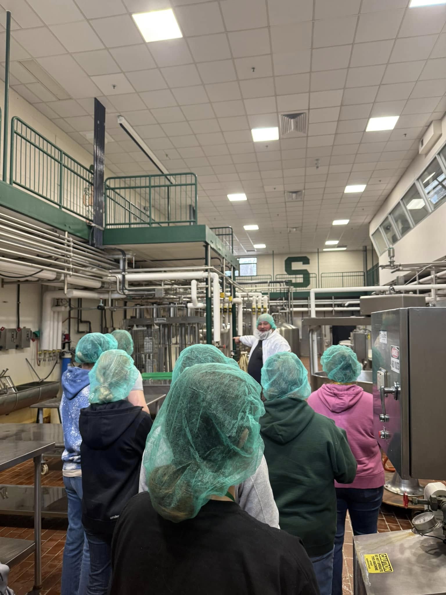 A group of conference attendees participate in a tour of the MSU Dairy Processing Center. 