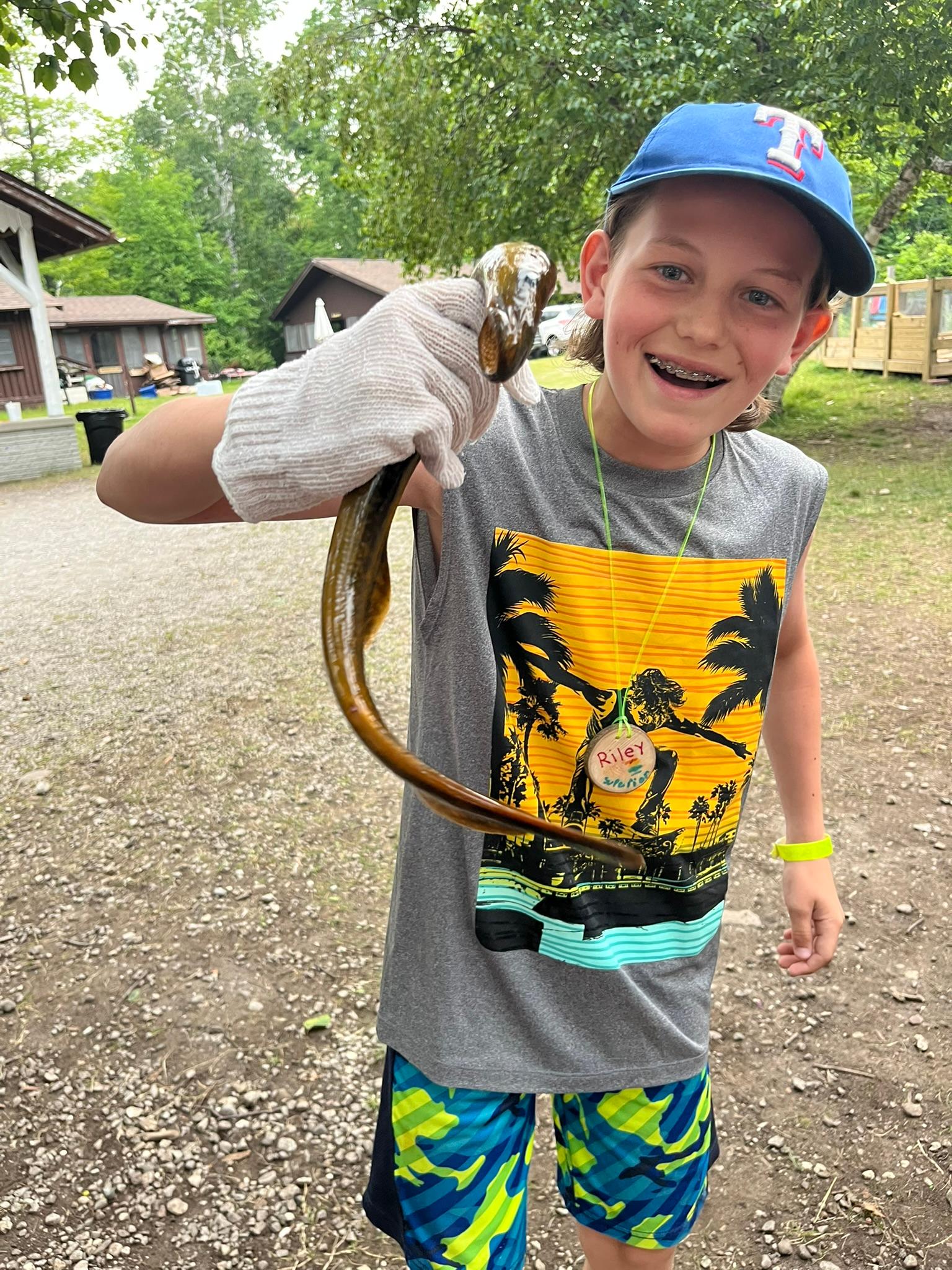 Teen wearing a white glove holds a live sea lamprey.