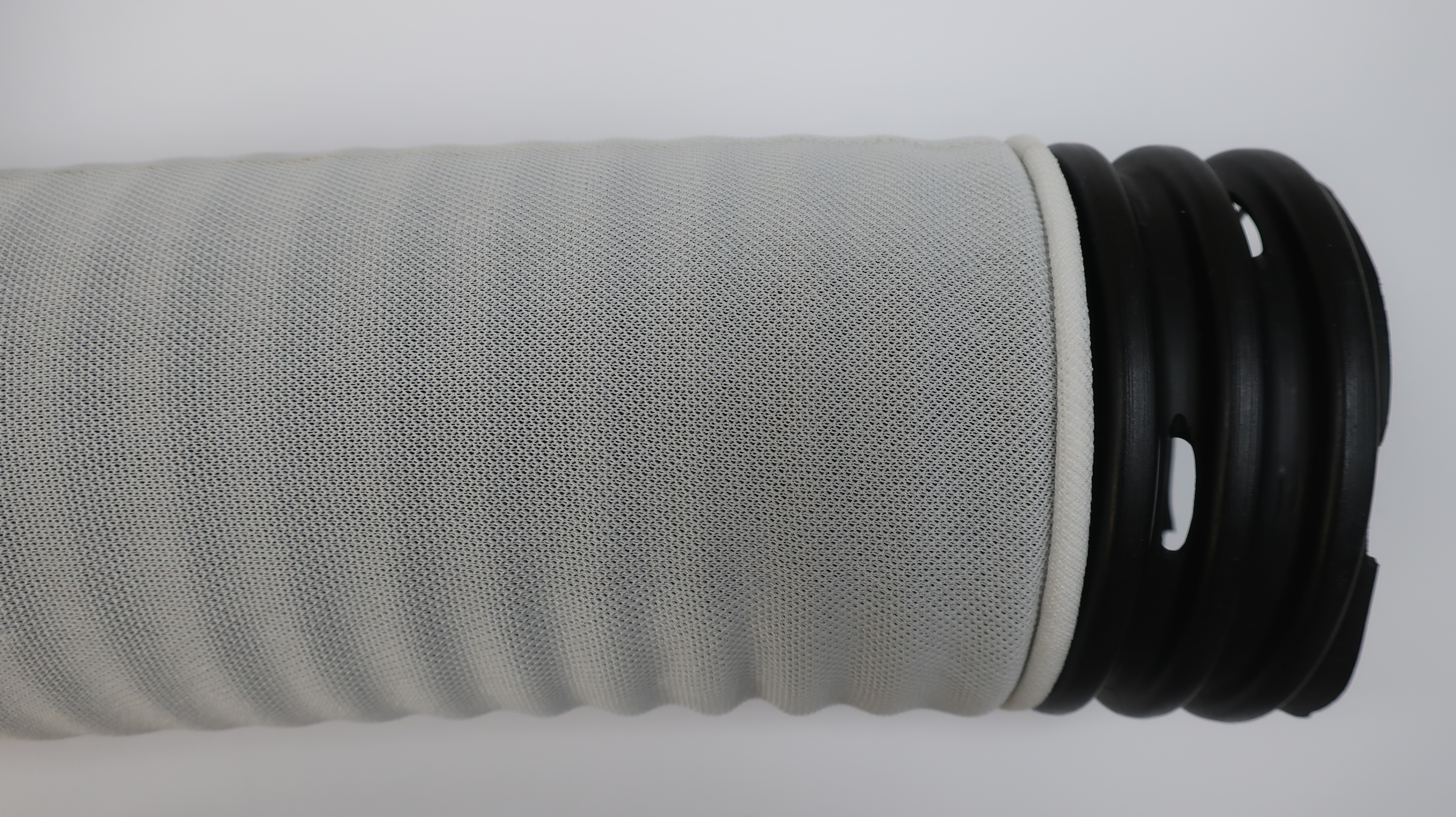 Figure 5- A muck pipe wrapped with a knitted sock envelope. The muck pipe has large oval perforations that reduce the chance of iron ochre clogging compared to narrow slotted pipes.